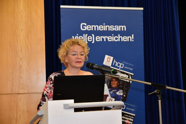 Gabiele Hradetzky steht an einem Podium und hält einen Vortrag Gabiele Hradetzky steht an einem Podium und hält einen Vortrag